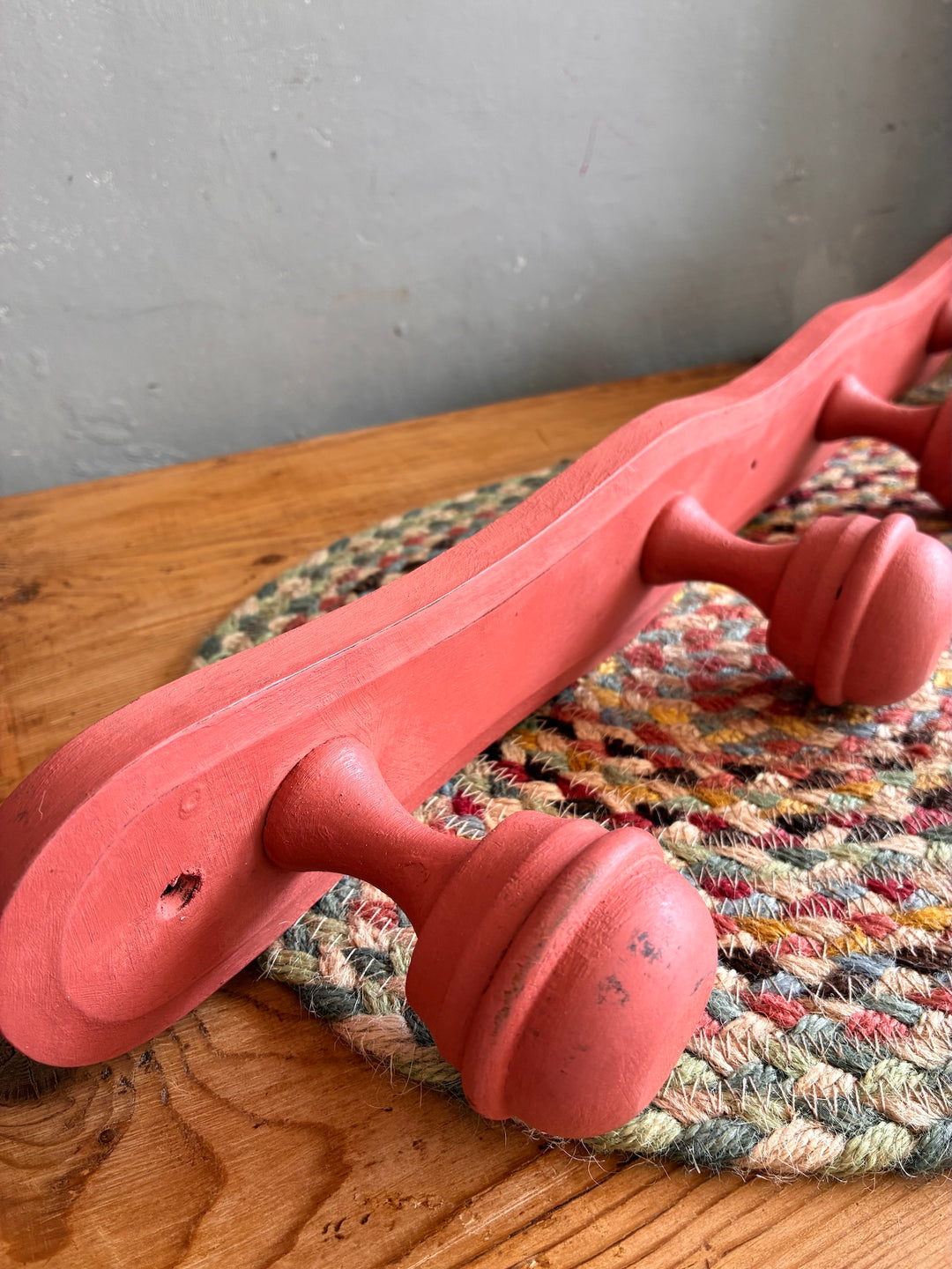 Earthy Pink Vintage French Coat Hooks on a wooden surface with a woven mat underneath.