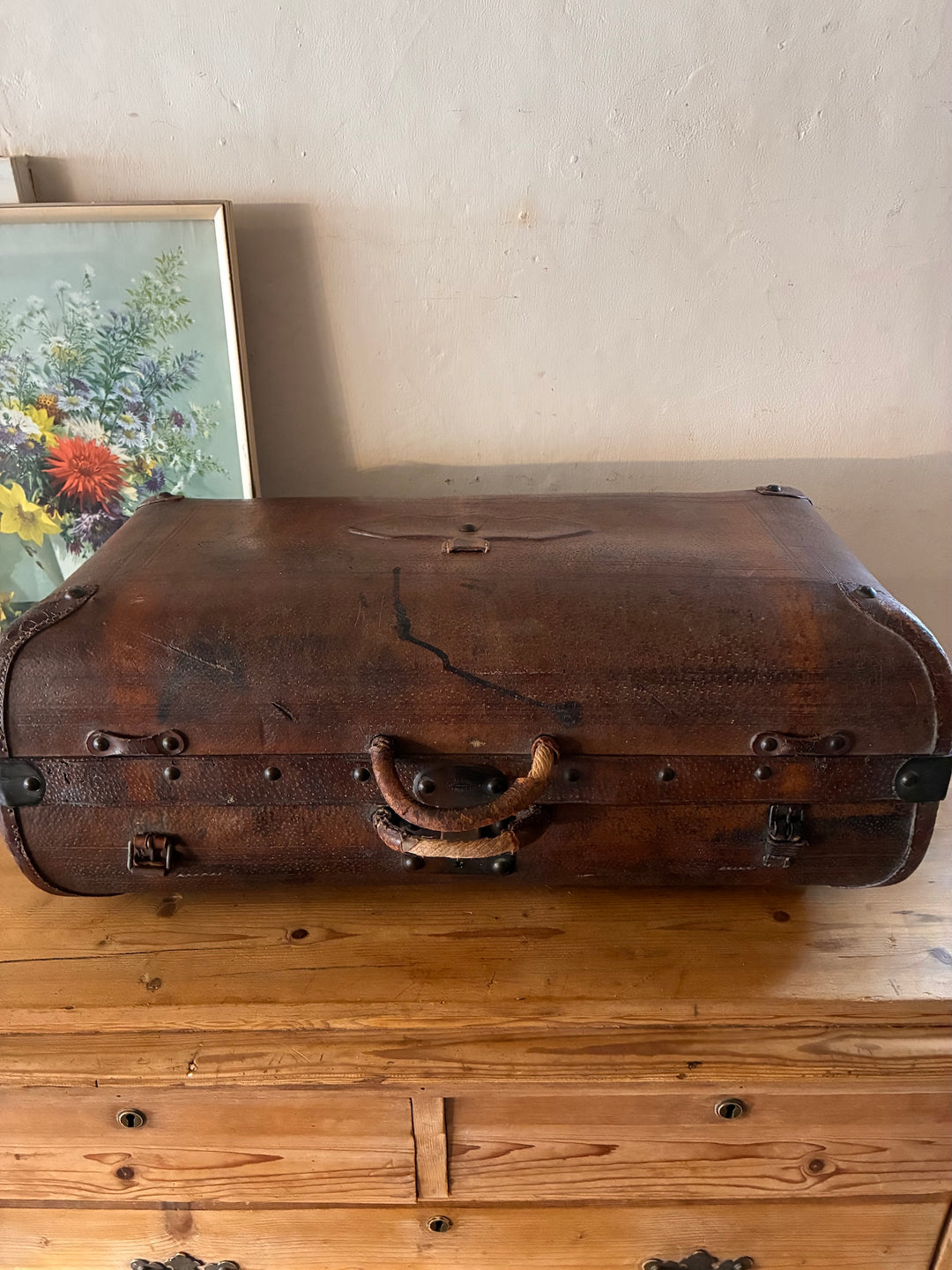 Vintage French Leather Suitcase with rustic charm, displaying well-worn patina and rounded corners.