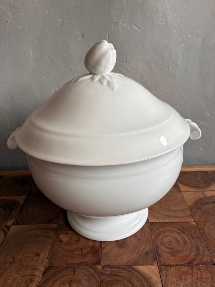 Vintage White Porcelain French Tureen with intricate lid and handles on a wooden surface.