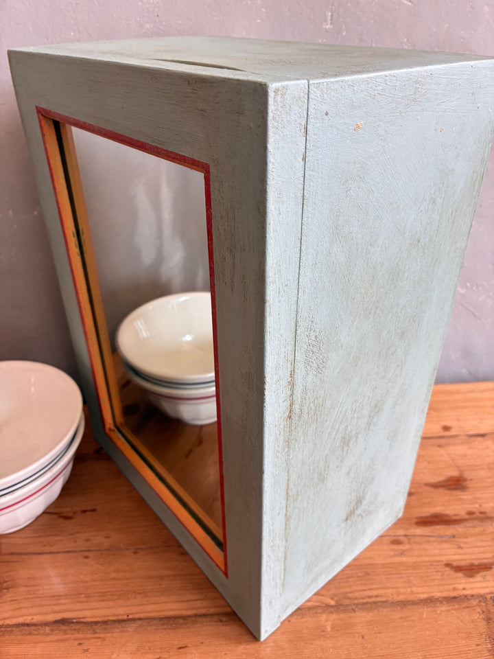 Vintage mirrored wall cabinet in soft blue with orange accents, perfect for storage and style. Source for the Goose, Devon.