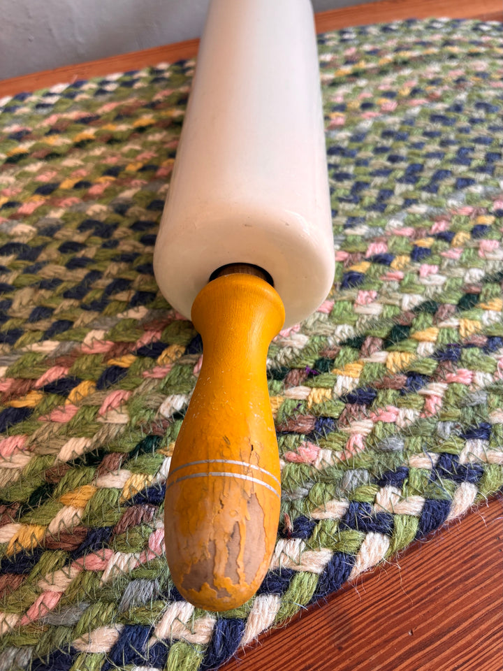 Vintage Nutbrown Rolling Pin with yellow wooden handles on a textured background, crafted for baking and nostalgia.