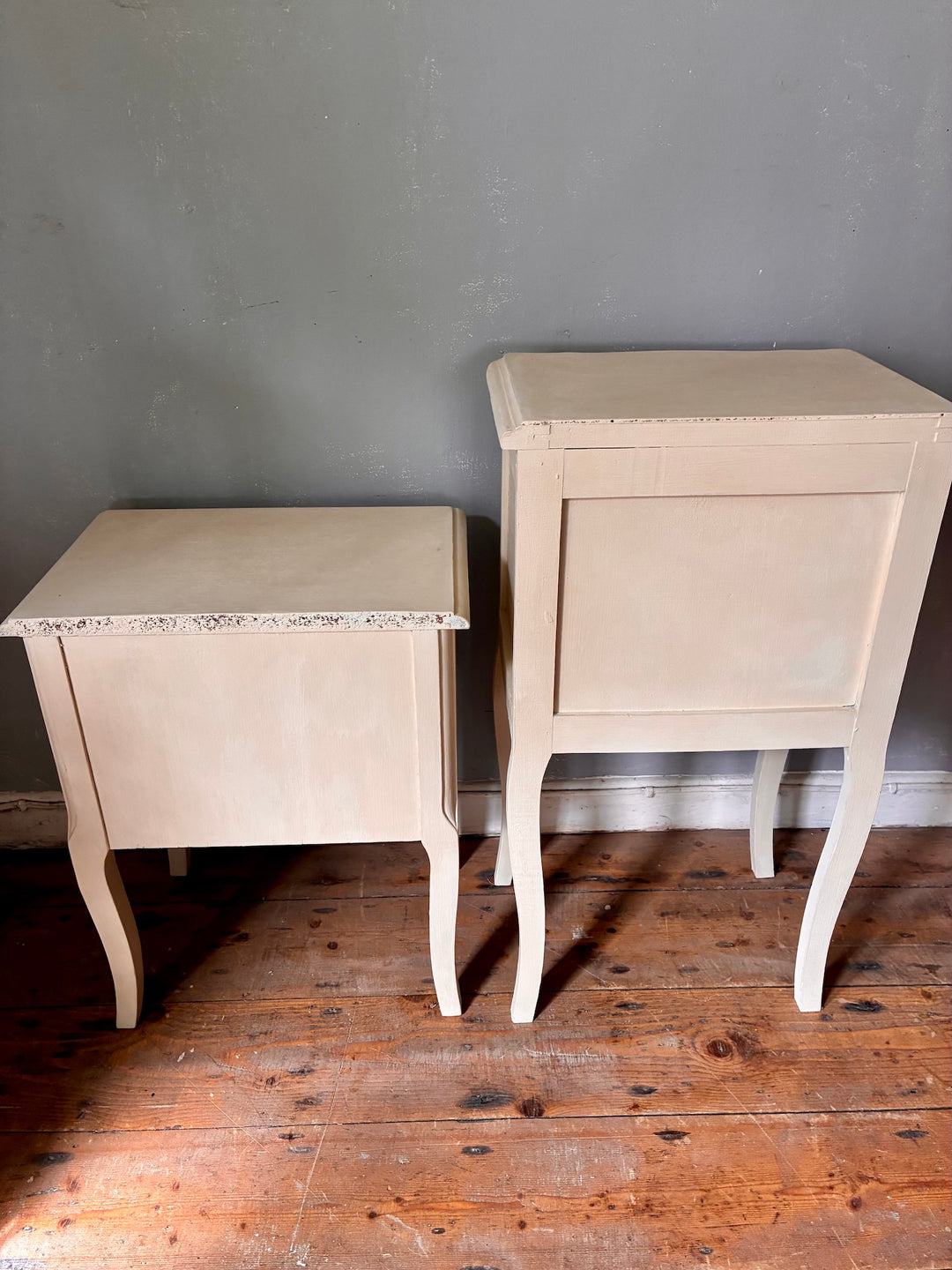 Vintage Painted French Bedside Tables - His and Hers displayed against a grey wall.