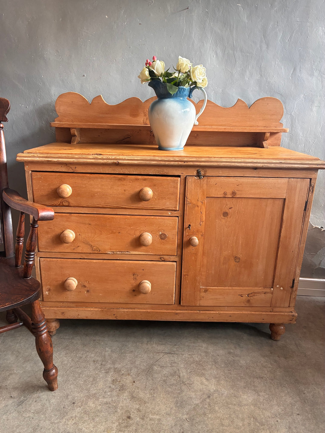 Small Victorian Pine Dresser with Galleried Back with blue and white jug filled with flowers on top, windsor chair to the left