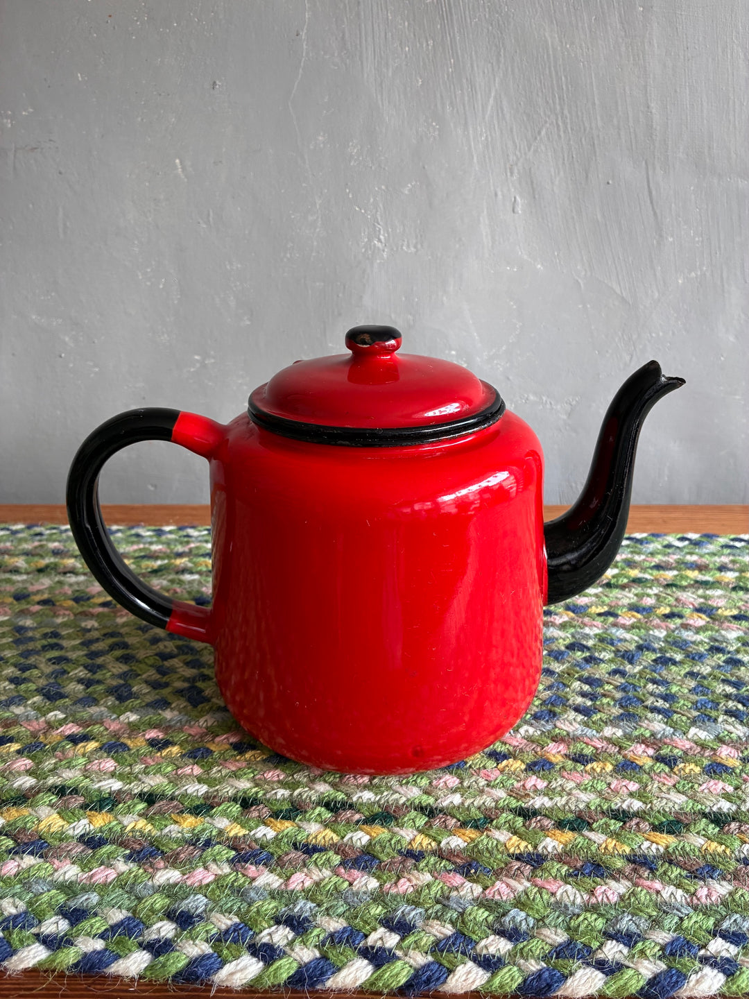 Vintage red enamel teapot with black handle and spout by Source for the Goose, perfect for tea or as a decorative vase.