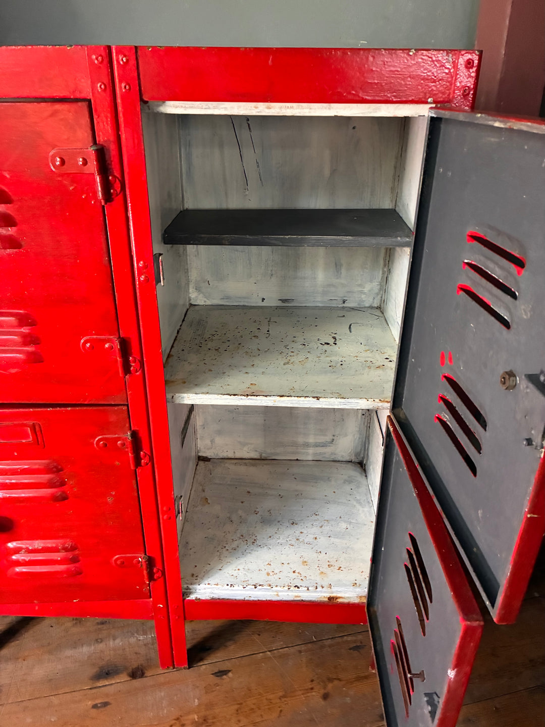 Interior view of the Red Metal Four Door Storage Locker featuring shelves and metal doors.