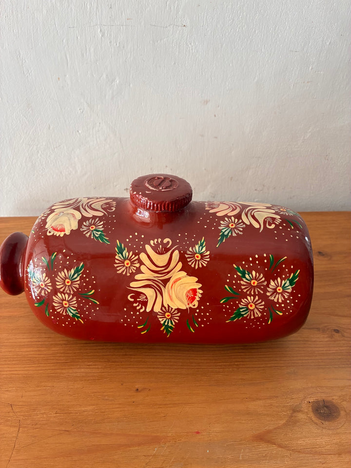 Vintage Royal Doulton Stoneware Foot Warmer - Painted Toleware with floral motifs on a brick red background.