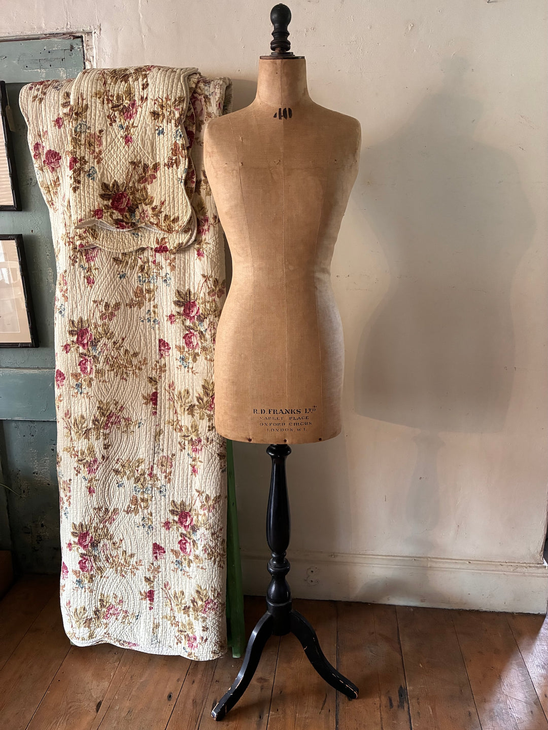 Vintage Shop Mannequin - Early 20th Century next to a floral fabric, showcasing its unique vintage character.