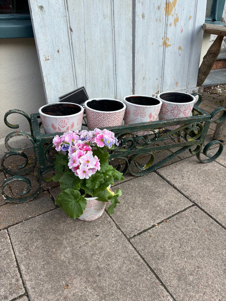 Vintage painted wrought iron trough planter with pink flowers, perfect for adding rustic charm to your outdoor space.