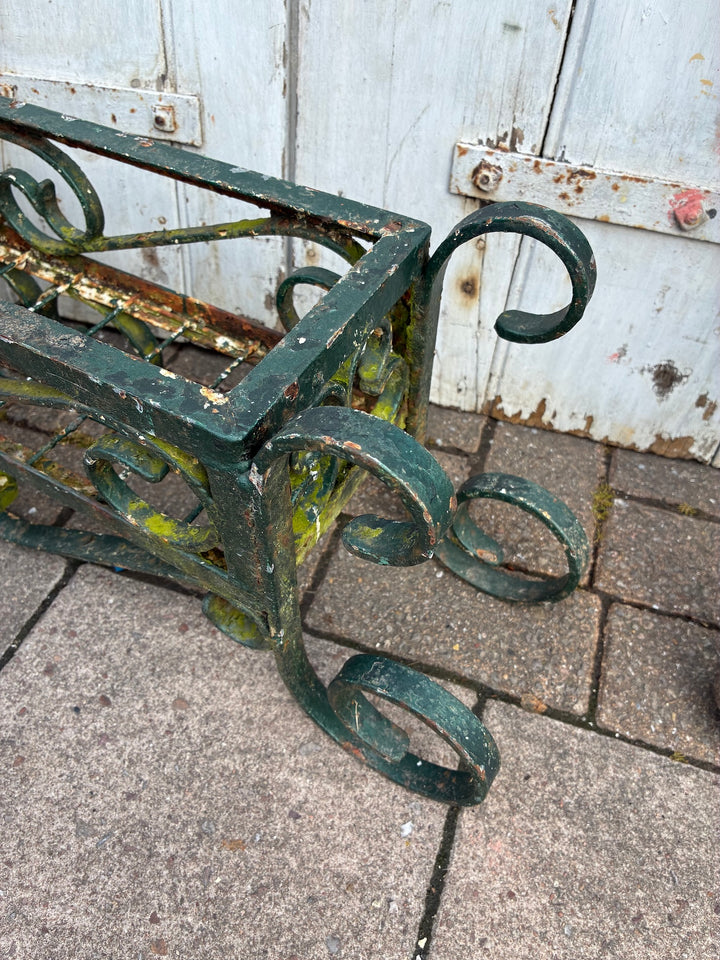 Vintage painted wrought iron trough planter with rustic green patina for outdoor gardening.