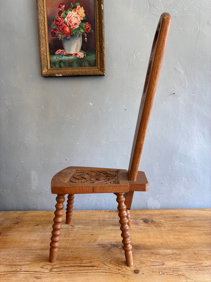 Side view of a Vintage Spinning Chair with carved light oak seat and unique backrest design.