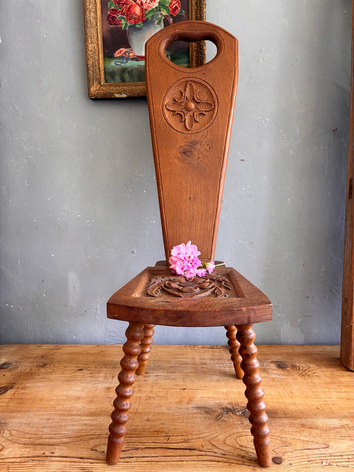 Vintage Spinning Chair with heart-shaped cutout and flower design on seat next to a floral artwork.