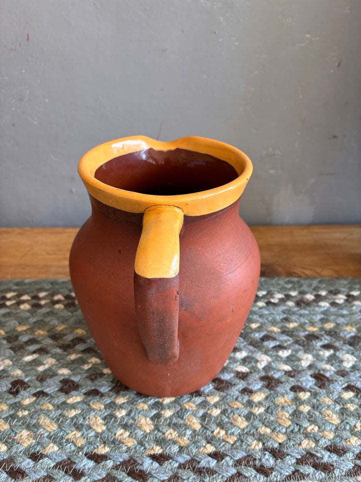 Vintage Terracotta Jug - Yellow Glaze Rim displayed on a textured background showcasing its rustic appeal.