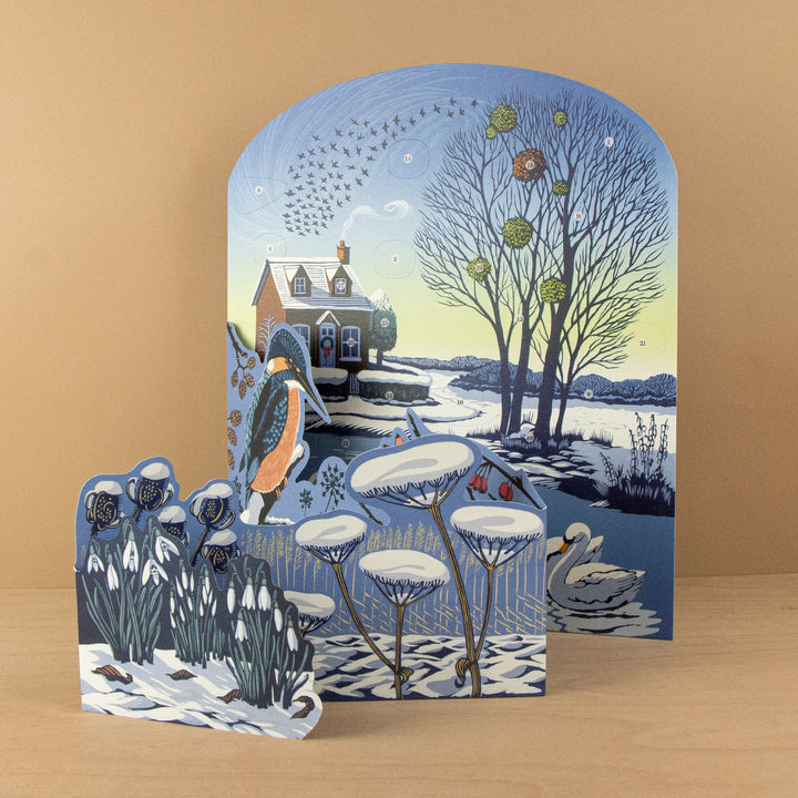 Winter Riverside Advent 2026 Calendar - Niki Bowers featuring a snowy pond and gingerbread cottage in winter scene.