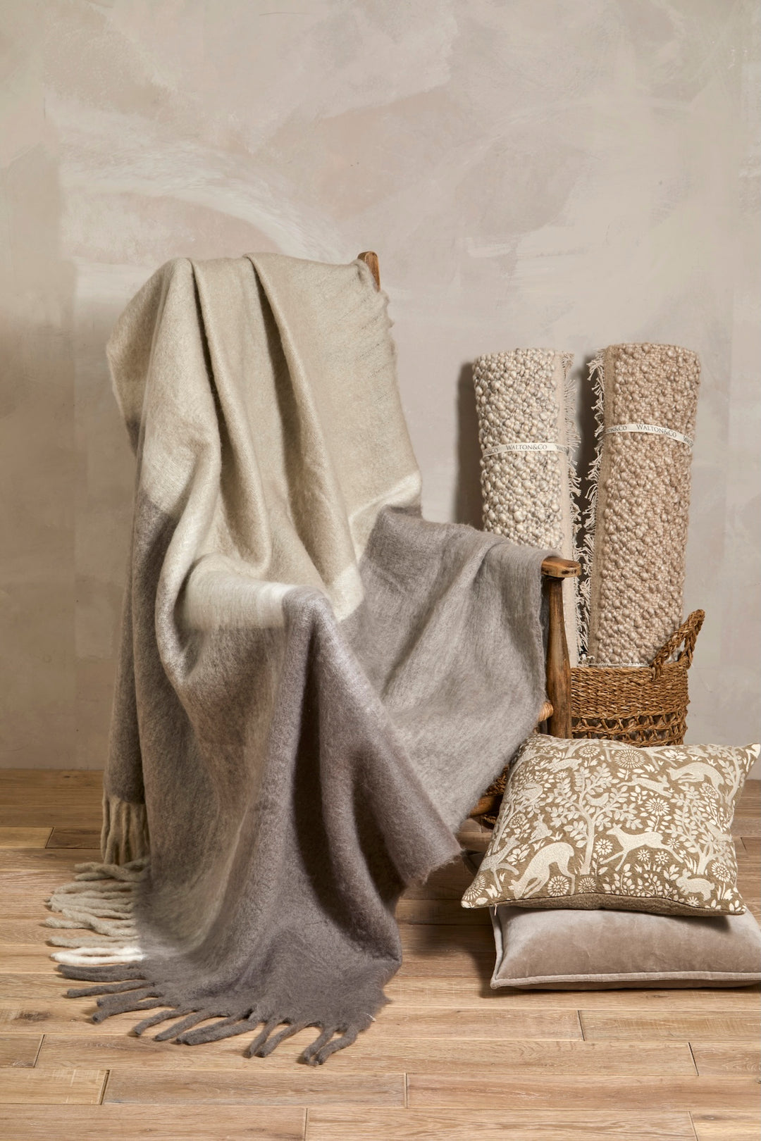 Embroidered Woodland Cushion with soft throw and textured pillows in a cozy setting.