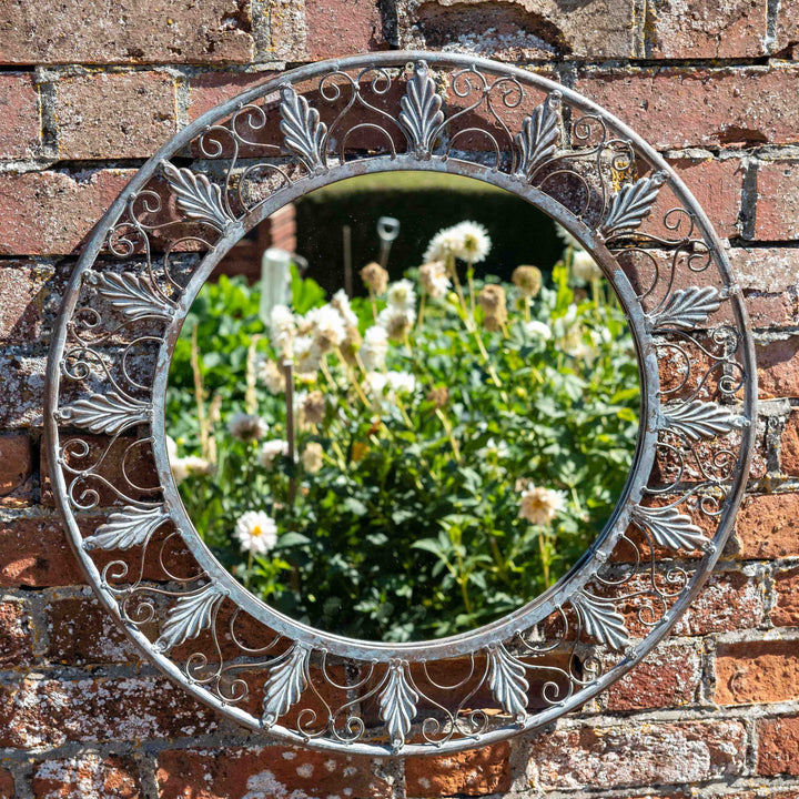 grey metal Round Garden Mirror fixed on a garden wall