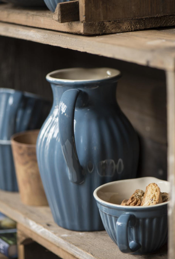 simple cornflower blue jug in a rustic setting